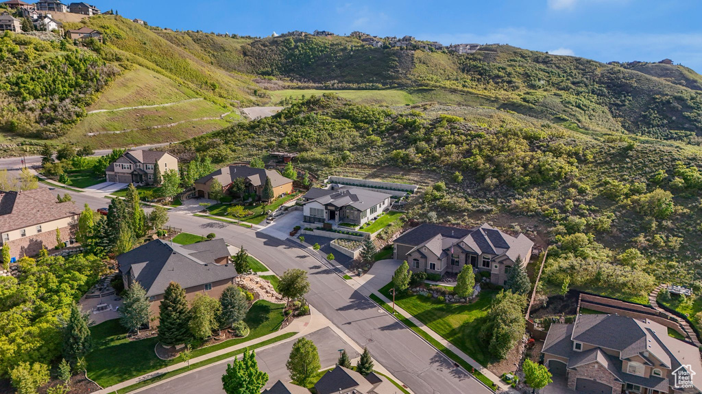 Aerial view of property's location with nearby suburban area and a mountainous background