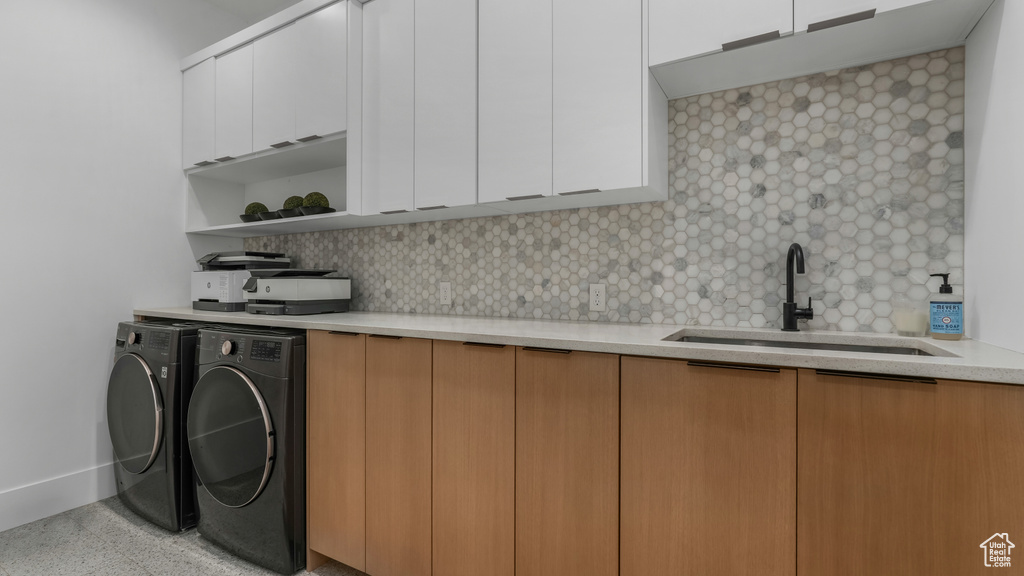 Laundry room with cabinet space, washing machine and dryer, and baseboards