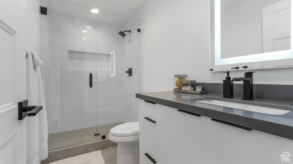 Bathroom with a stall shower, toilet, vanity, and recessed lighting