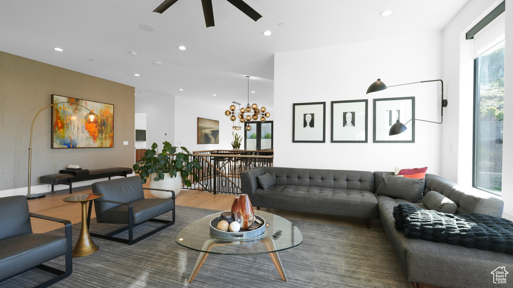 Living room with wood finished floors, recessed lighting, a chandelier, and ceiling fan