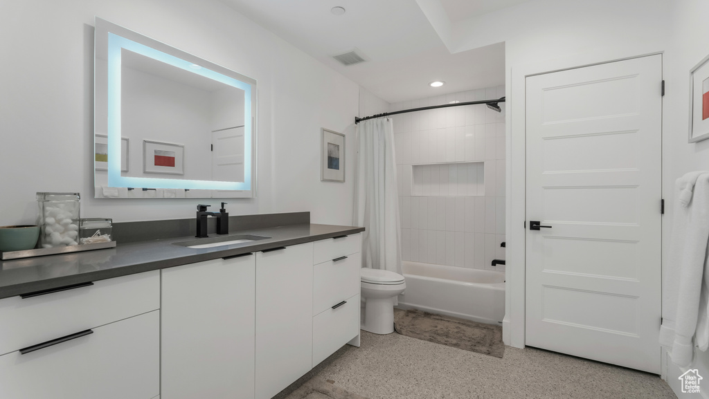 Full bath featuring speckle patterned floor, vanity, recessed lighting, shower / bath combo, and toilet