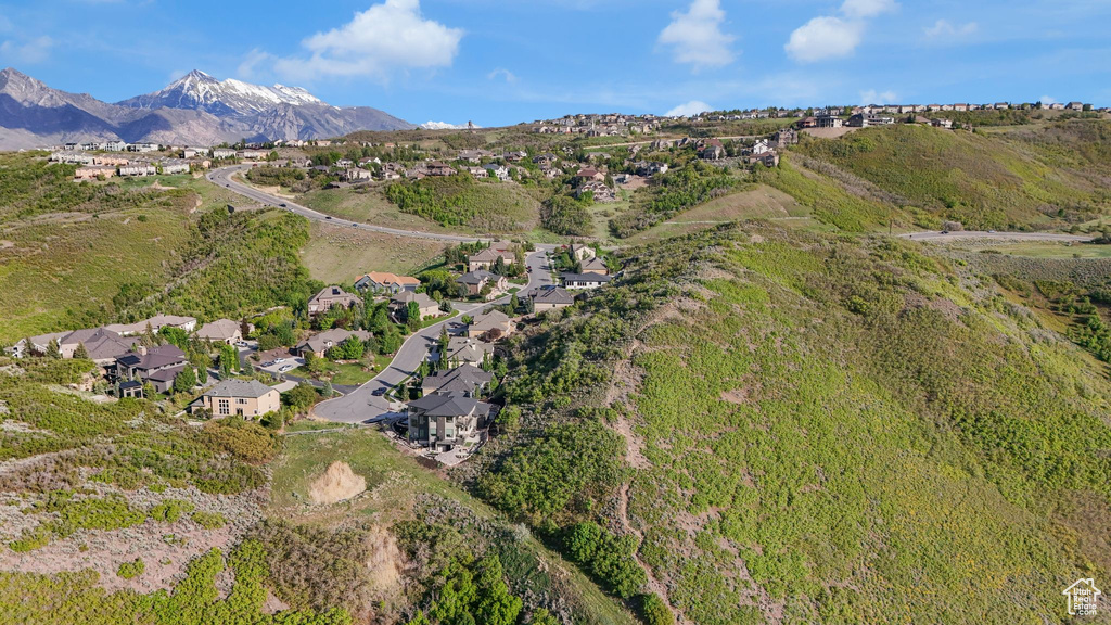 Aerial view of property and surrounding area with nearby suburban area and a mountain backdrop
