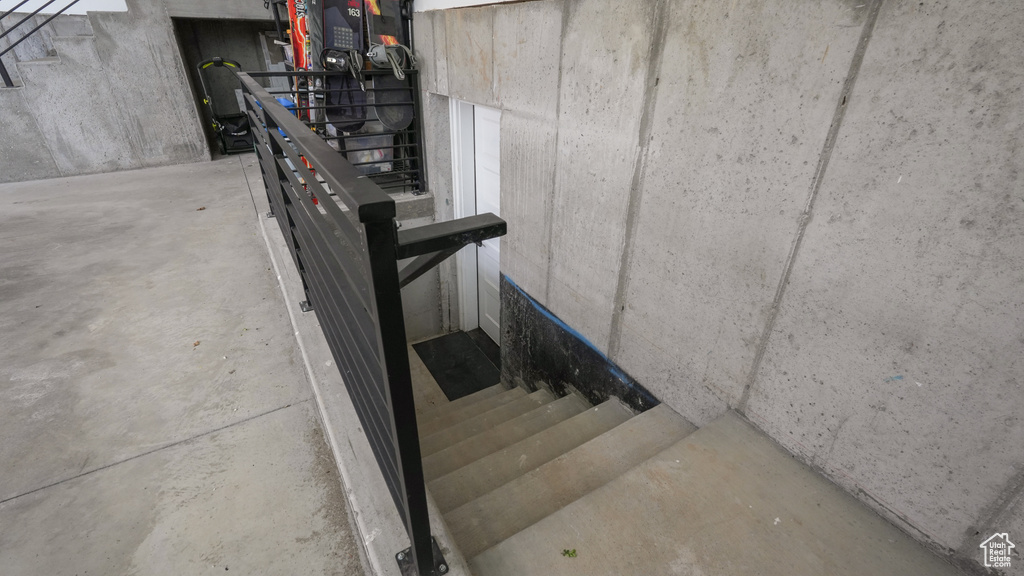 Stairway featuring unfinished concrete floors