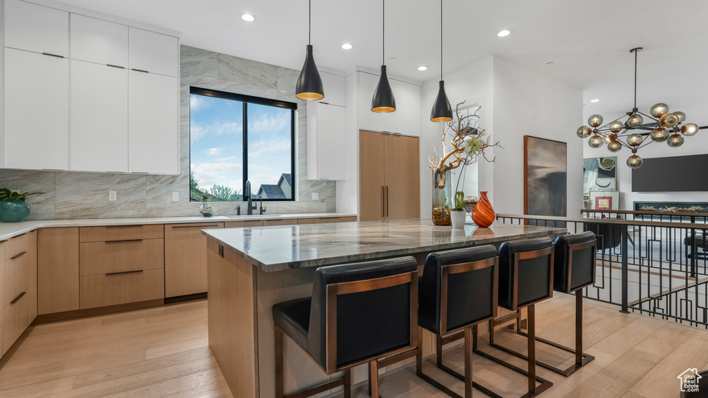 Kitchen with modern cabinets, dishwasher, a sink, a kitchen bar, and recessed lighting