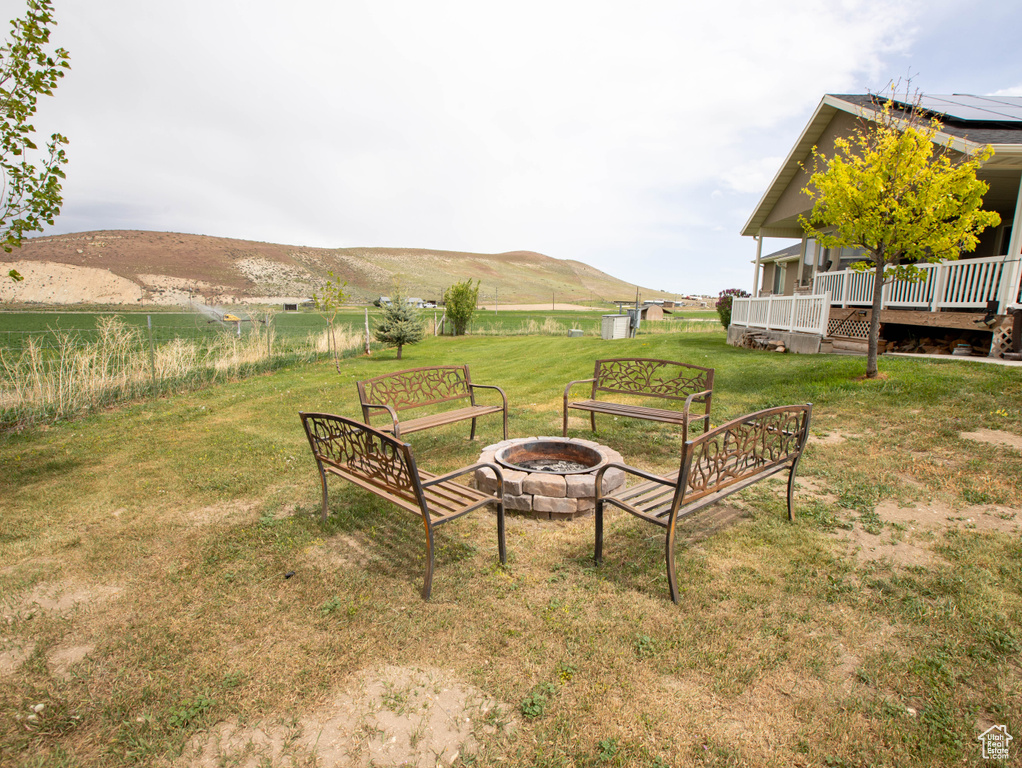 View of yard featuring an outdoor fire pit and a deck with mountain view