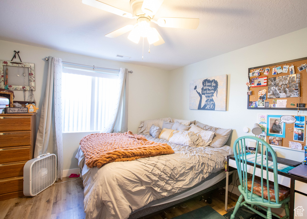 Bedroom featuring wood finished floors, ceiling fan, and baseboards