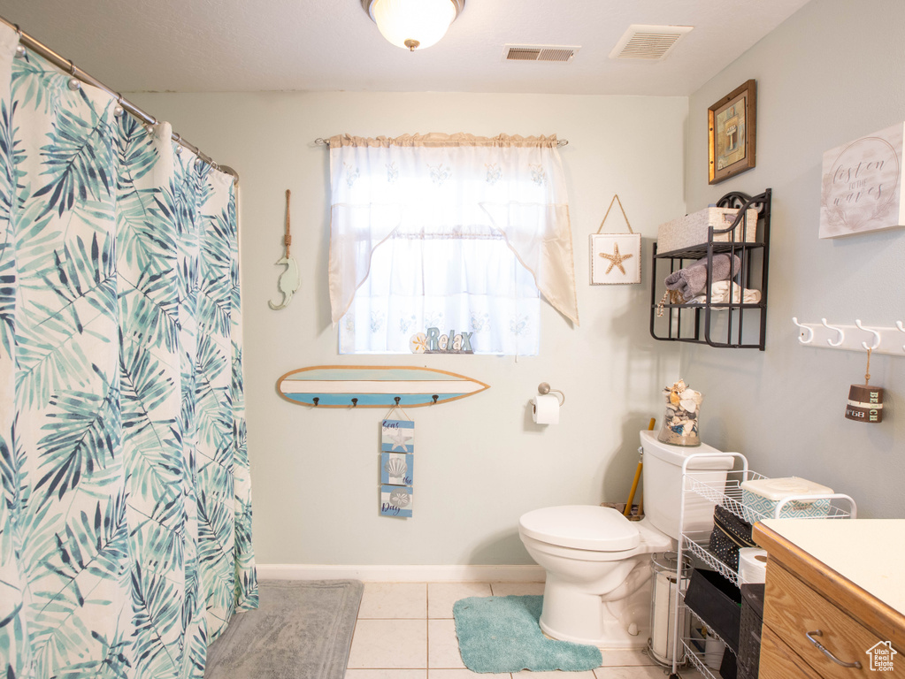 Bathroom featuring toilet, vanity, tile patterned flooring, and a shower with curtain
