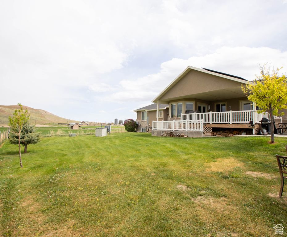 View of green lawn with a wooden deck