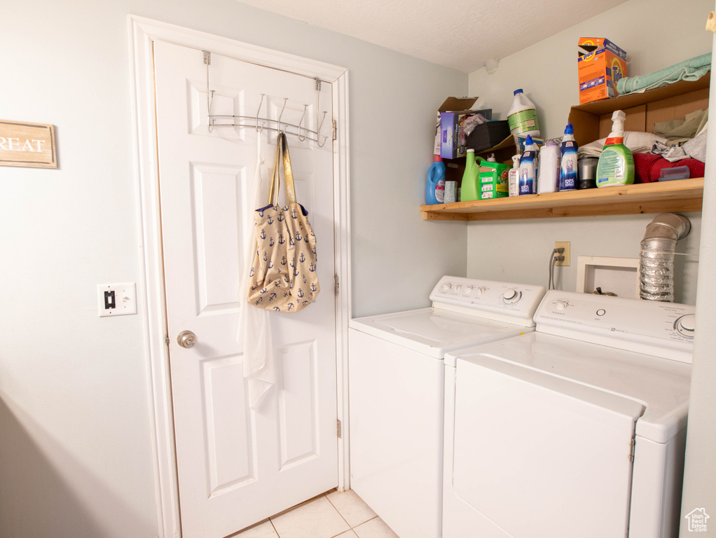Washroom featuring separate washer and dryer and light tile patterned flooring