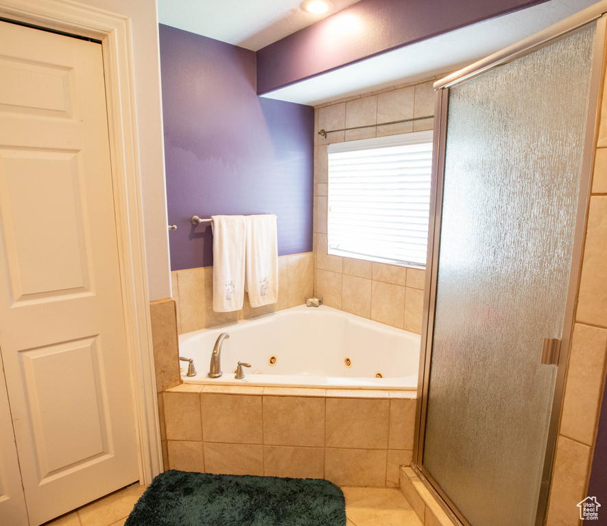 Bathroom with tile patterned flooring, a stall shower, and a tub with jets