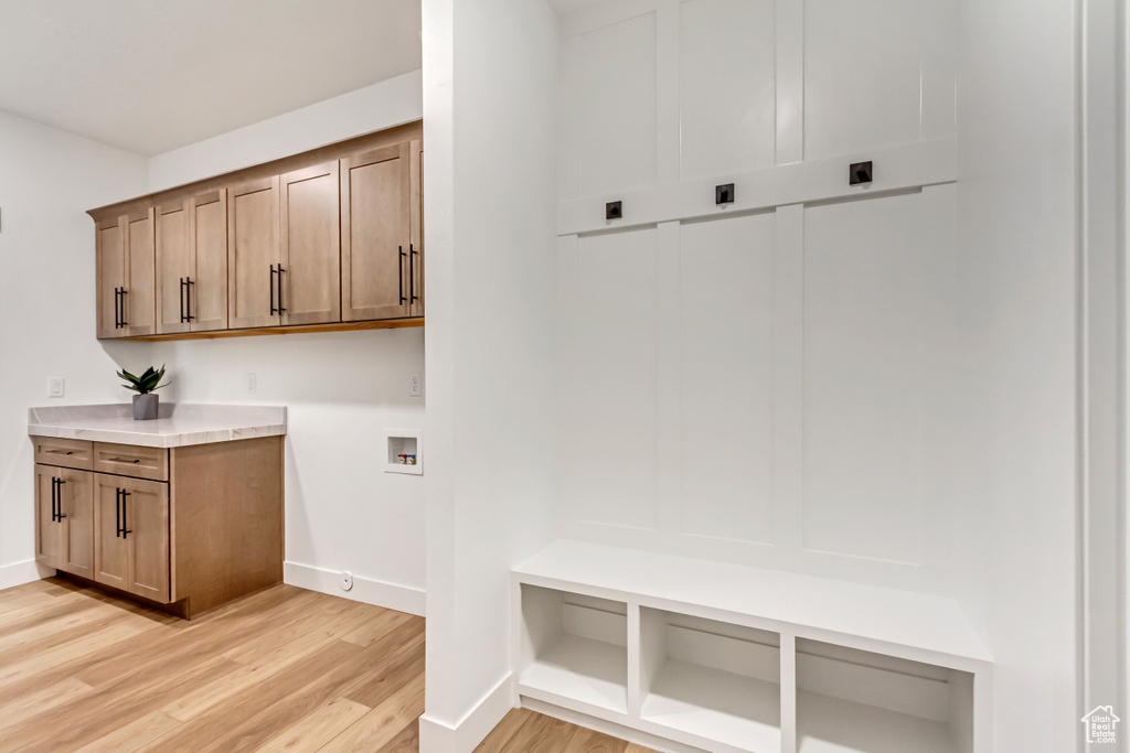 Mudroom featuring baseboards and light wood-style flooring