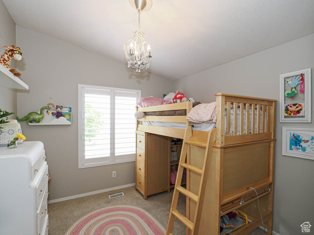 Bedroom featuring baseboards, a chandelier, and light carpet