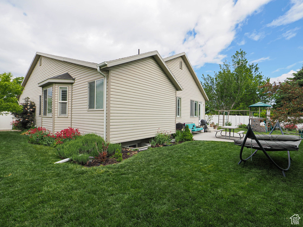 View of side of property with a patio and a playground