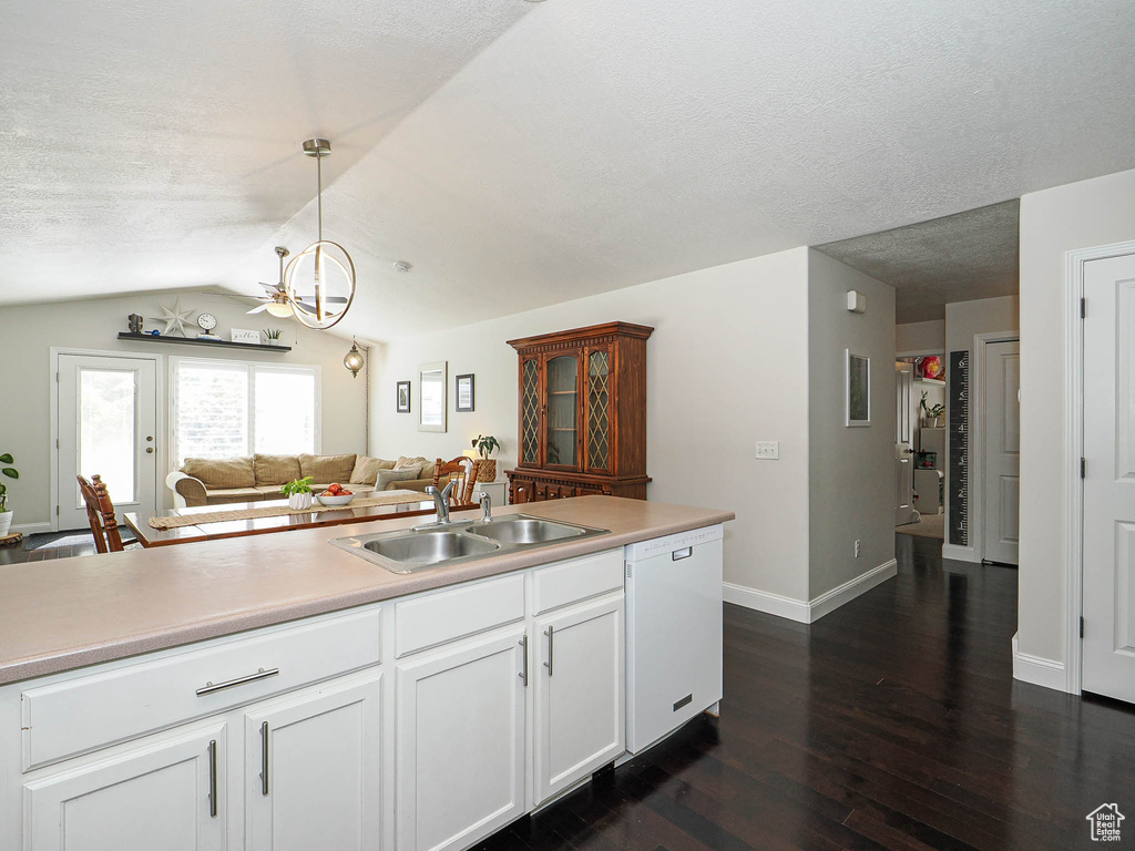Kitchen featuring dishwasher, a sink, dark wood-type flooring, lofted ceiling, and a chandelier