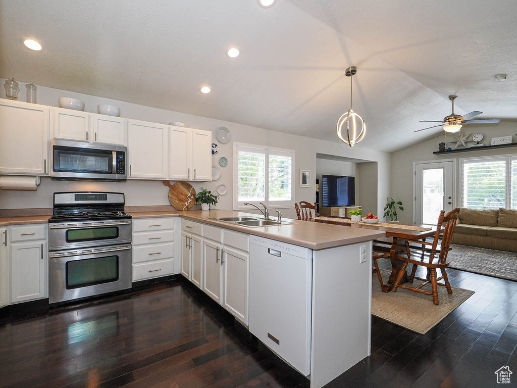 Kitchen with stainless steel appliances, a sink, open floor plan, a peninsula, and plenty of natural light