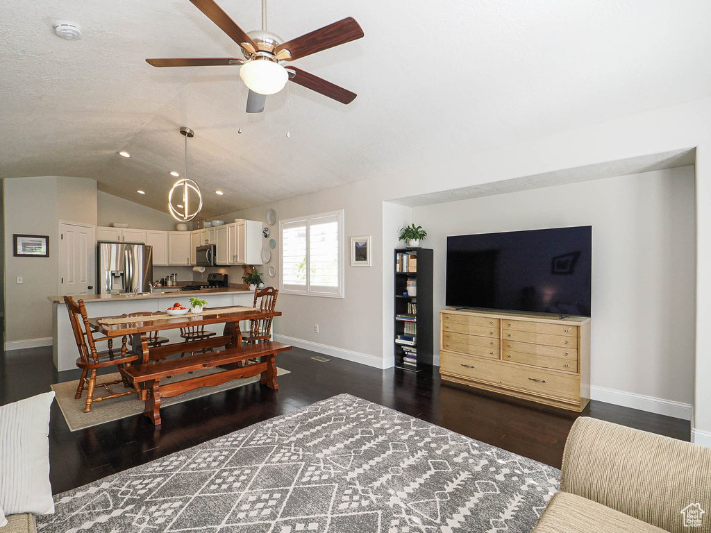 Dining room featuring baseboards, dark wood finished floors, ceiling fan, lofted ceiling, and recessed lighting