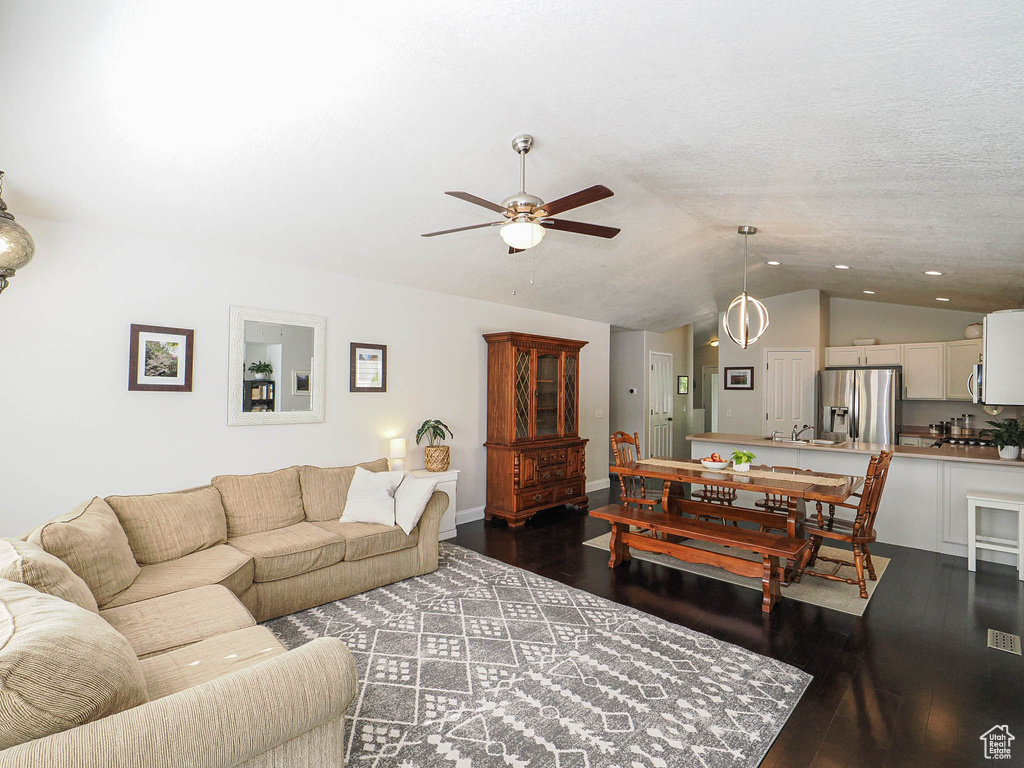 Living room featuring vaulted ceiling, ceiling fan, dark wood-style floors, and recessed lighting