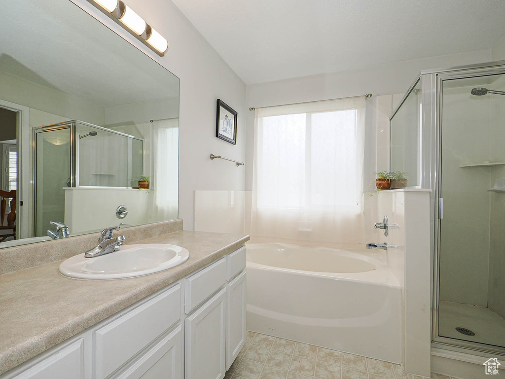 Bathroom featuring a stall shower, vanity, and a bath