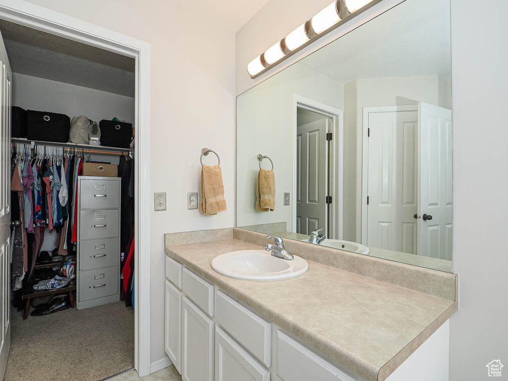 Bathroom with vanity and a spacious closet