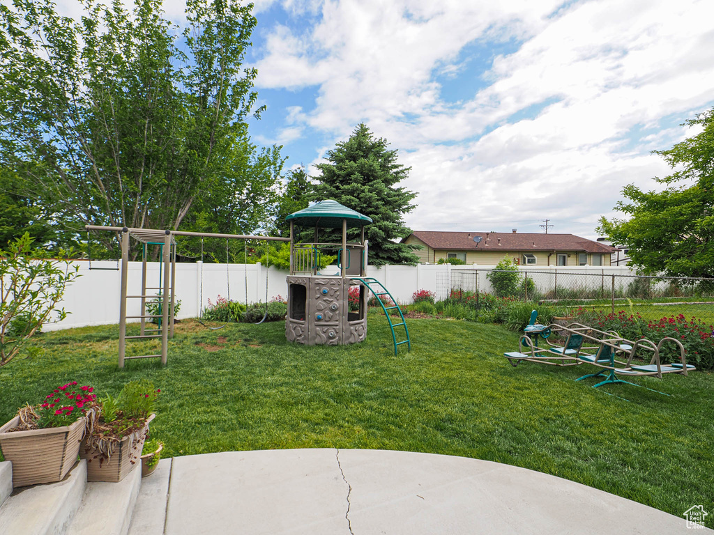 View of yard featuring a playground and a patio