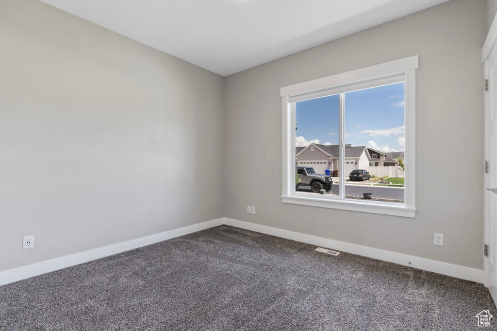 Carpeted empty room with baseboards