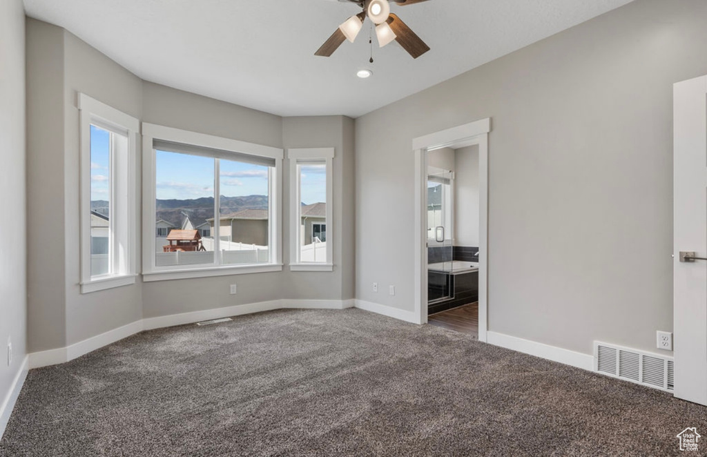 Carpeted spare room with ceiling fan, baseboards, and recessed lighting