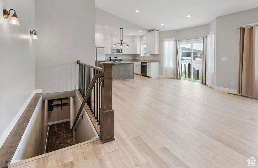 Stairs with wood finished floors, recessed lighting, baseboards, and lofted ceiling