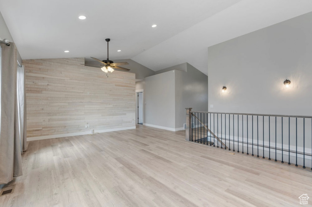 Unfurnished room featuring ceiling fan, wood finished floors, lofted ceiling, recessed lighting, and baseboards
