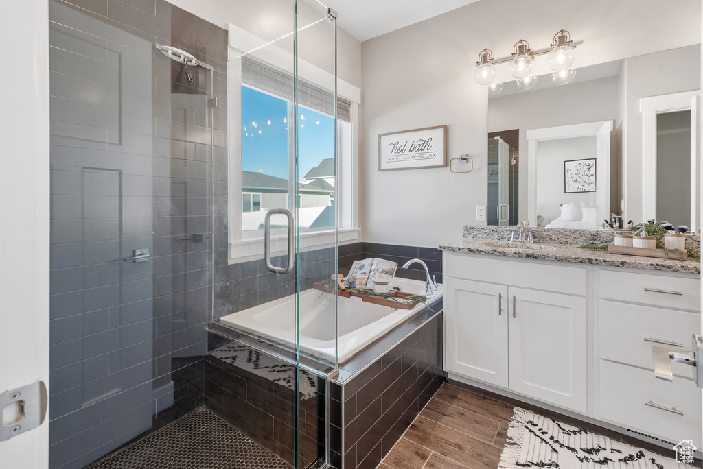 Bathroom with a shower stall, a bath, and vanity