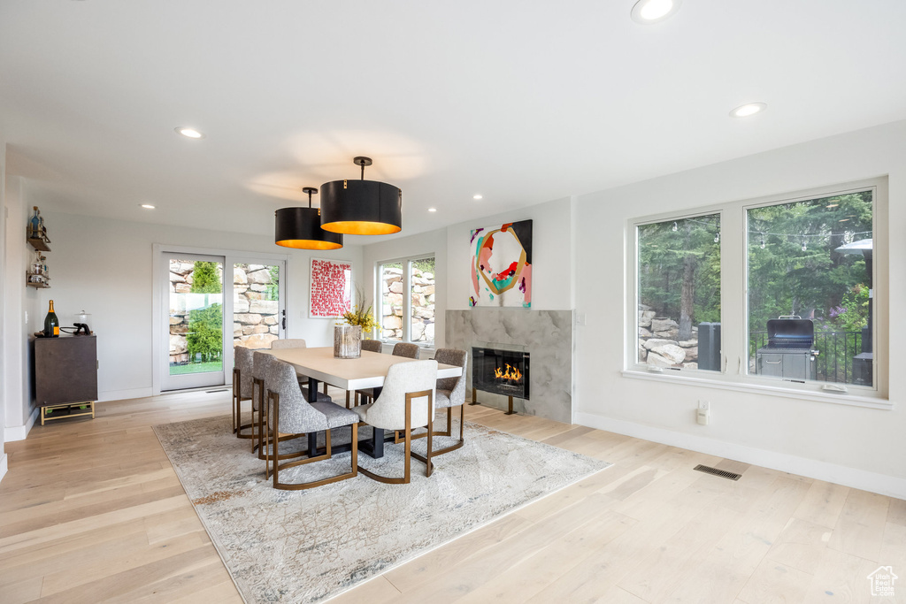Dining area featuring baseboards, recessed lighting, light wood-type flooring, and a fireplace