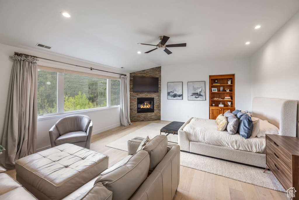 Living area with ceiling fan, light wood-type flooring, a fireplace, recessed lighting, and vaulted ceiling