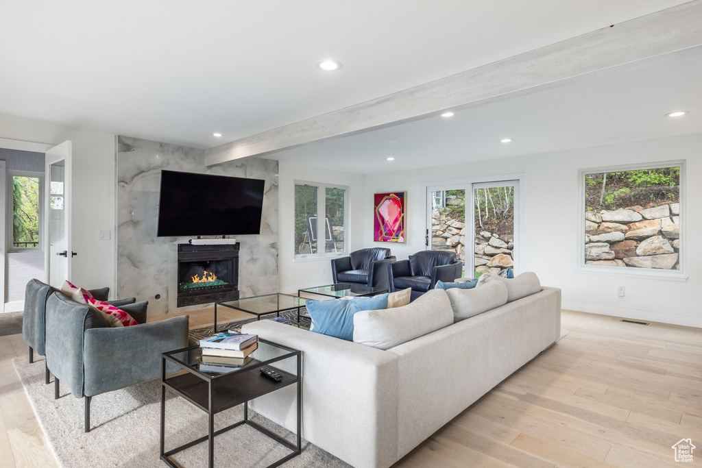 Living area featuring recessed lighting, beam ceiling, light wood-style floors, a high end fireplace, and baseboards