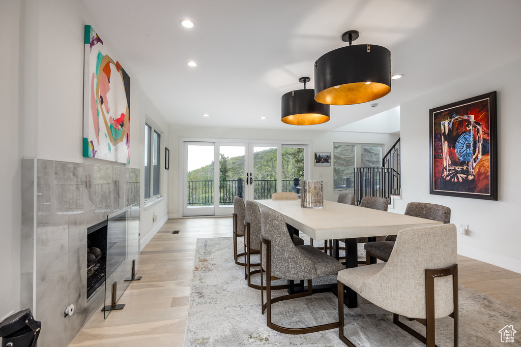 Dining room featuring recessed lighting, stairway, light wood finished floors, a tiled fireplace, and baseboards