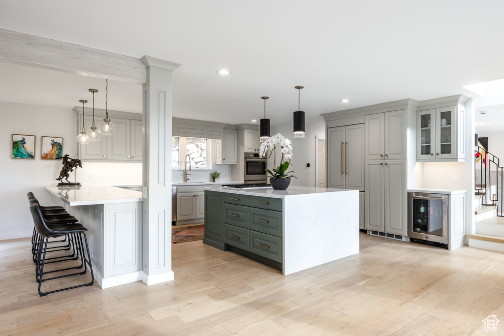 Kitchen with oven, beverage cooler, recessed lighting, a peninsula, and light countertops