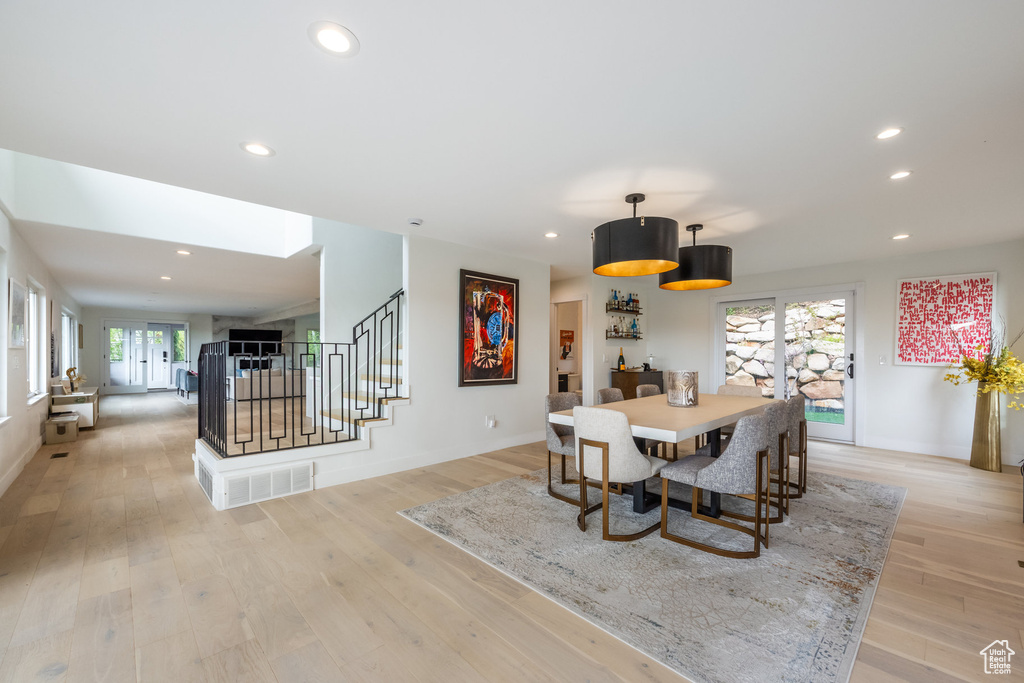 Dining room with stairs, light wood-type flooring, recessed lighting, and baseboards