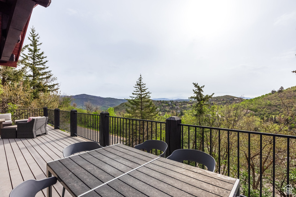 Wooden terrace with outdoor dining space, an outdoor living space, and a mountain view