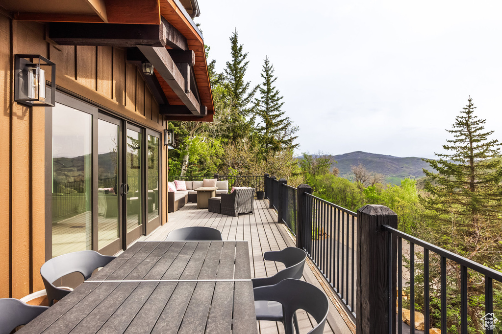 Wooden terrace featuring a mountain view, an outdoor hangout area, and outdoor dining space