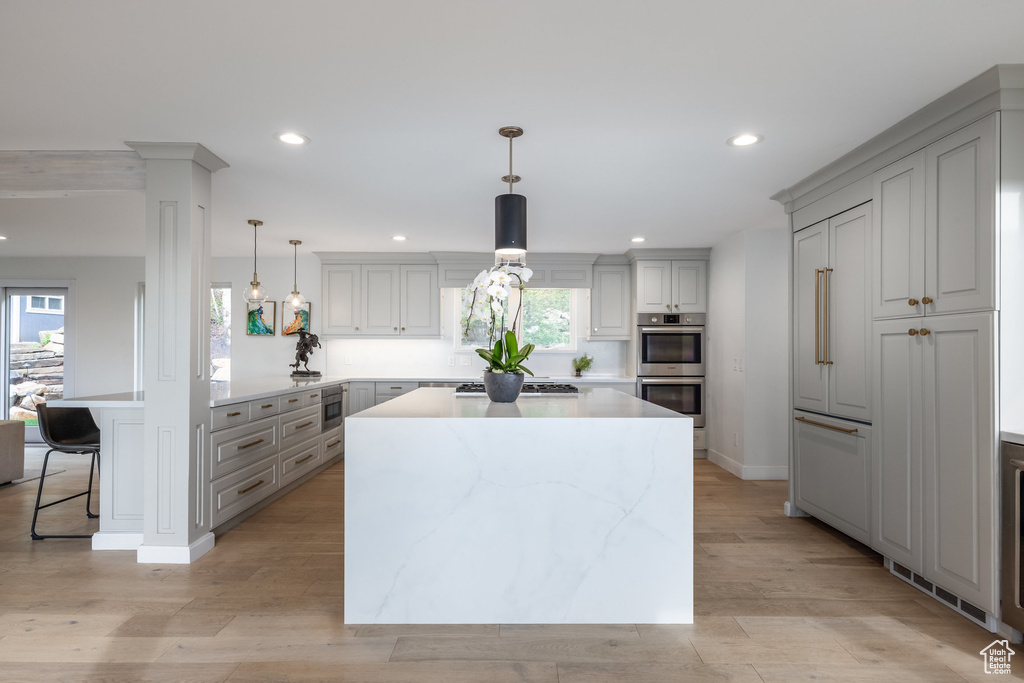 Kitchen with stainless steel appliances, a peninsula, recessed lighting, a kitchen breakfast bar, and healthy amount of natural light