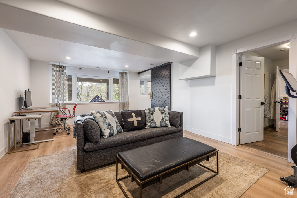 Living room featuring light wood-style flooring, baseboards, an office area, and recessed lighting