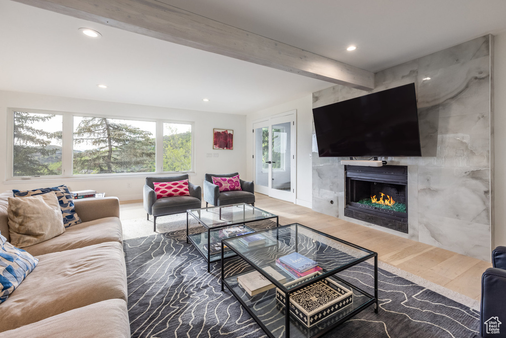 Living area featuring wood finished floors, recessed lighting, a high end fireplace, and beam ceiling