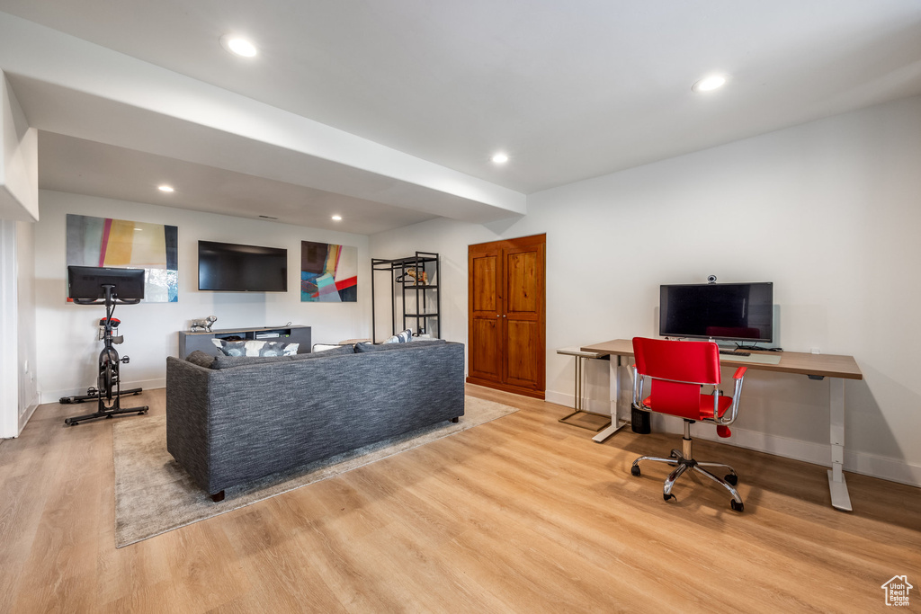 Living room with wood finished floors, a desk, recessed lighting, and baseboards