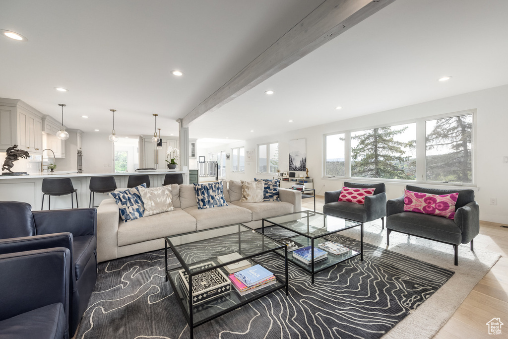 Living room with recessed lighting, light wood finished floors, and beamed ceiling