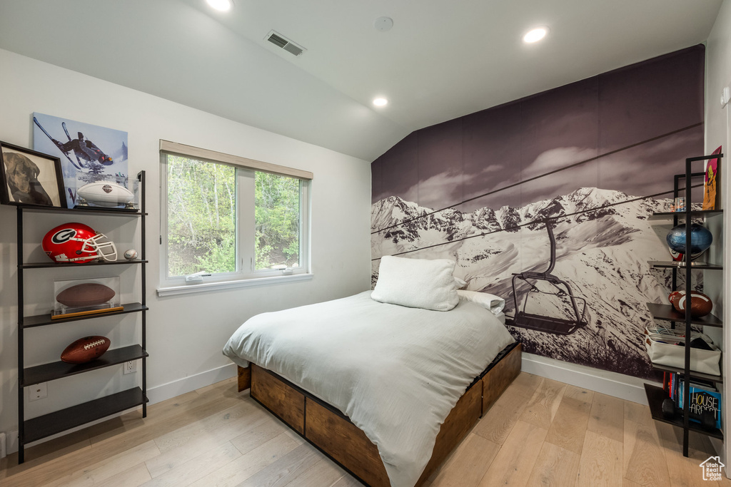 Bedroom with baseboards, wood finished floors, vaulted ceiling, and recessed lighting