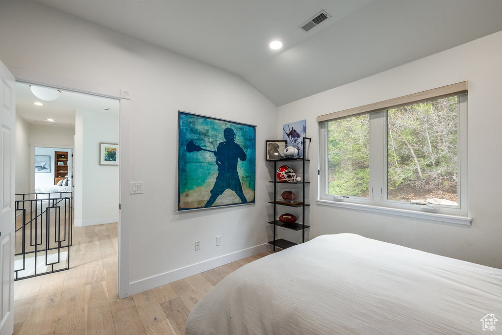 Bedroom with light wood-style floors, lofted ceiling, baseboards, and recessed lighting