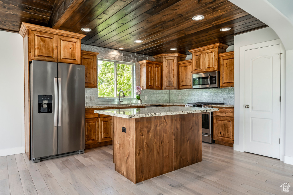 Kitchen featuring appliances with stainless steel finishes, wooden ceiling, a kitchen island, brown cabinetry, and recessed lighting