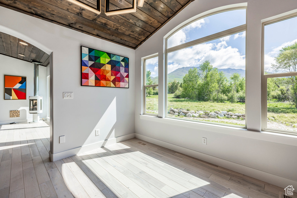Interior space featuring wooden ceiling, a mountain view, hardwood / wood-style floors, vaulted ceiling, and baseboards