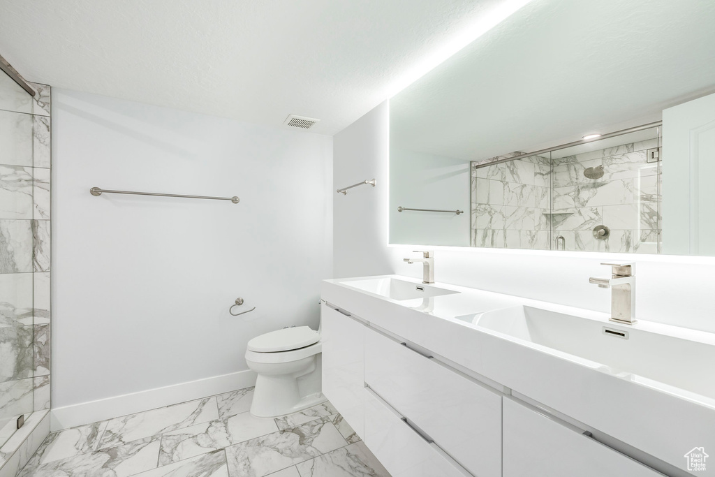 Bathroom with marble finish flooring, a marble finish shower, toilet, and baseboards