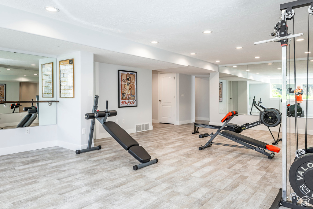 Exercise area featuring baseboards, recessed lighting, and wood finished floors