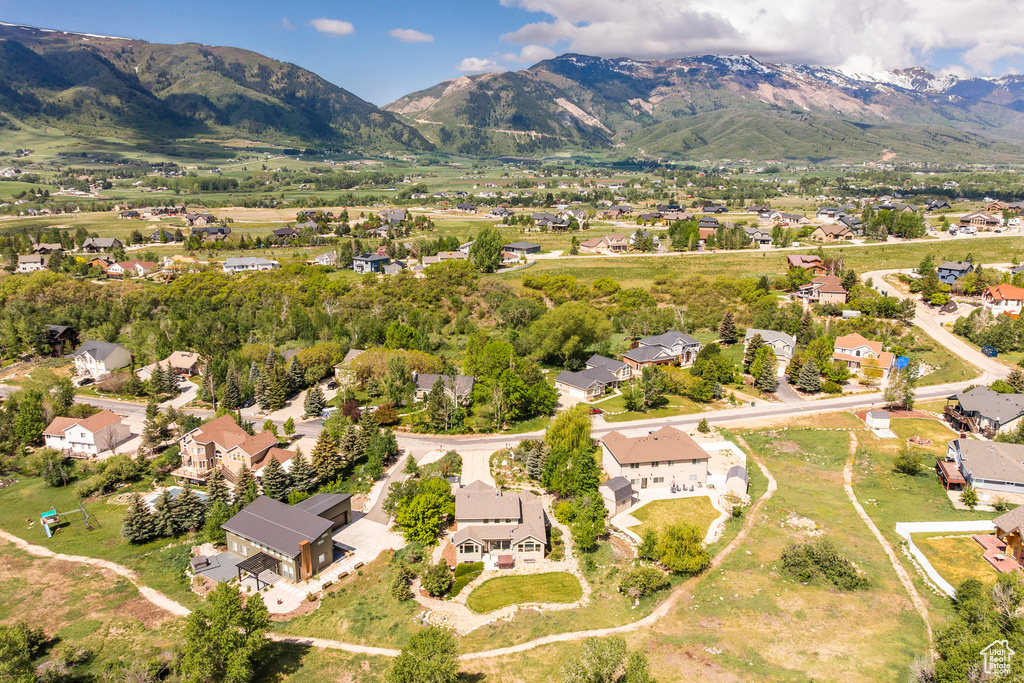Aerial view of property's location with nearby suburban area and a mountainous background