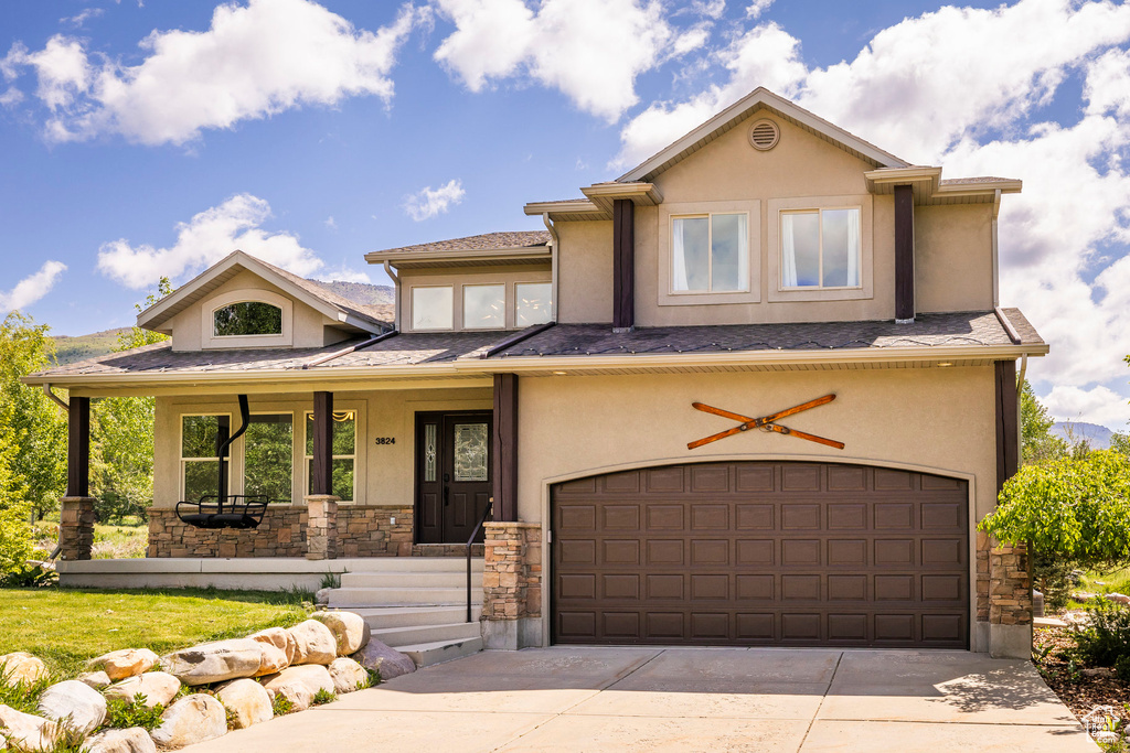 View of front of property featuring stucco siding, stone siding, an attached garage, and concrete driveway